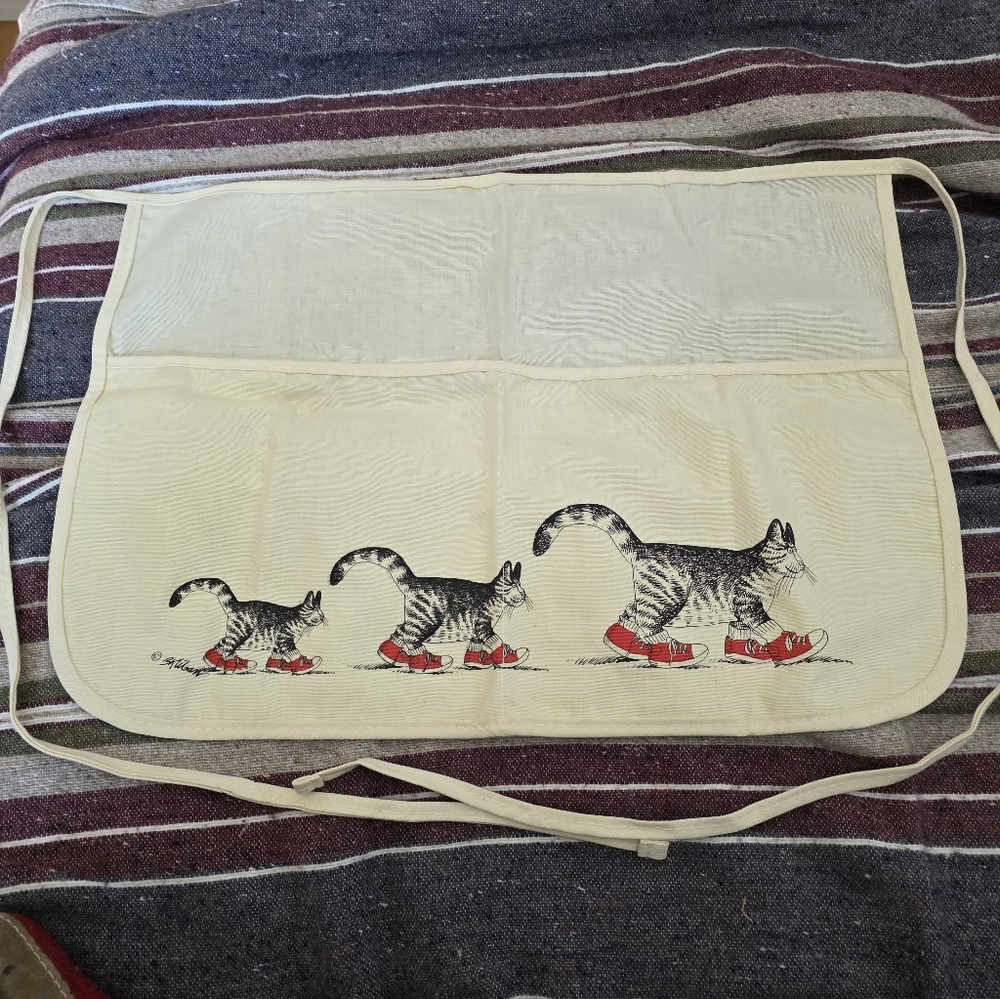 Vintage white apron features the iconic "Cat with Sneakers" illustration